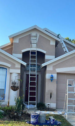 Exterior 2 story house with windows masked to keep safe for painting.